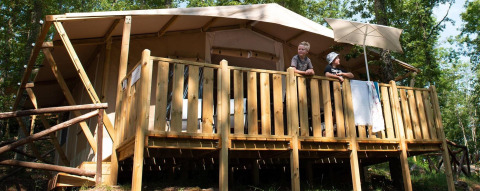 Deux personnes sur la terrasse d’une Lodge Tent Deluxe à Vacanze Glamping Boutique en Italie.