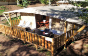 Lodge Tent Deluxe safari tent at Vacanze Glamping Boutique, Italy, featuring a wooden terrace and outdoor furniture.