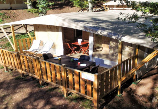 Tente safari Lodge Tent Deluxe au Vacanze Glamping Boutique en Italie, avec terrasse et mobilier extérieur.