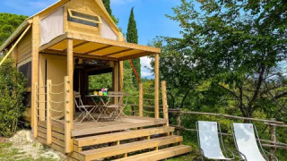 The ‘Air Dreamer’ safari tent at Vacanze Glamping Boutique in Italy, featuring a wooden deck and nature views.