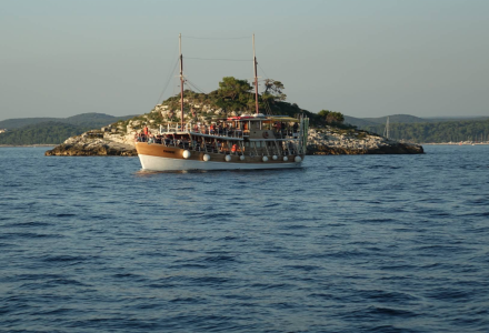 Houten boot op het water bij een klein eiland dichtbij Rovinj, Istrië, Kroatië, op een heldere dag.