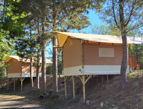 Safari tent Bivouac Comfort op Camping Le Val de Cesse in Frankrijk, verhoogd tussen de bomen.
