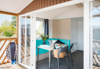Luminosa e moderna Beach Lodge ad Arden Parks Tulderheyde, Belgio, con terrazza e tavola da surf fuori.