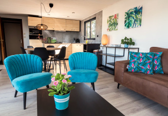 Trendy woonkamer in Luxe Lodges bij Arden Parks Tulderheyde, België, met kleurrijke blauwe stoelen.