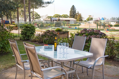 Buitentafel met stoelen en wijnopstelling bij Luxe Lodges, Arden Parks Tulderheyde in België.