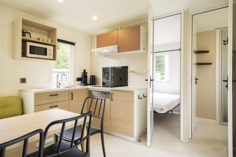 Moderna cucina e zona pranzo a Cordelia Lodges di Arden Parks Tulderheyde, Belgio, con vista camera da letto.