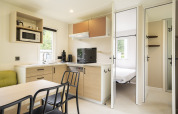 Moderne køkken- og spiseområde i Cordelia Lodges på Arden Parks Tulderheyde, Belgien, med soveværelse.