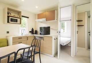 Moderna cucina e zona pranzo a Cordelia Lodges di Arden Parks Tulderheyde, Belgio, con vista camera da letto.