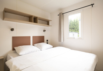 Camera luminosa e moderna ai Cordelia Lodges, Arden Parks Tulderheyde, Belgio, con letto matrimoniale e finestra.