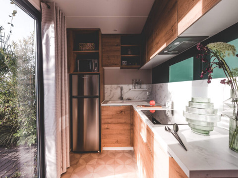 Cucina moderna presso O'Hara Lodge ad Arden Parks Tulderheyde, Belgio, con mobili in legno e grandi finestre.