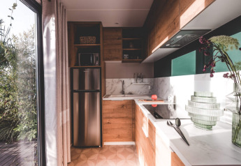Cucina moderna presso O'Hara Lodge ad Arden Parks Tulderheyde, Belgio, con mobili in legno e grandi finestre.