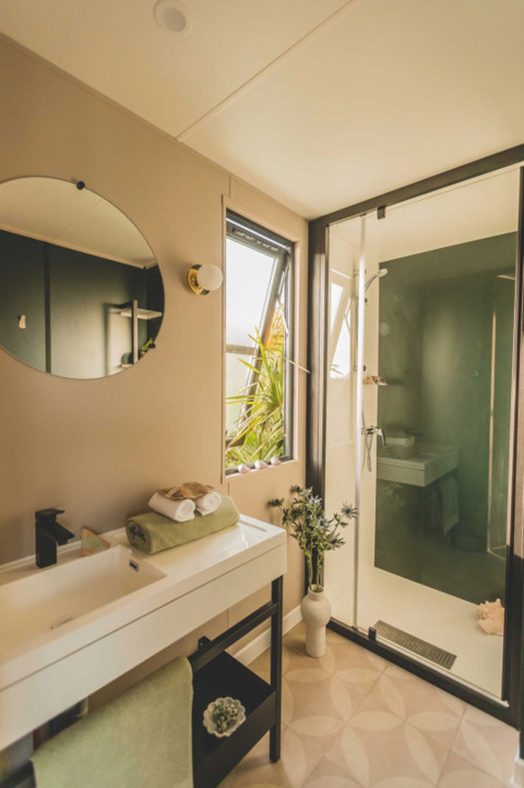 Bagno moderno presso O'Hara Lodge, Arden Parks Tulderheyde, Belgio, con doccia, specchio e piante.