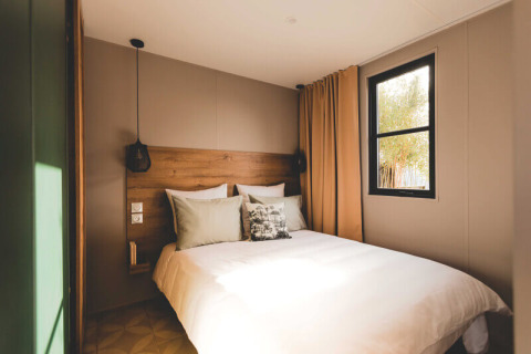 Camera da letto doppia accogliente presso O'Hara Lodge Comfort ad Arden Parks Tulderheyde, Belgio, con grande letto e finestra.