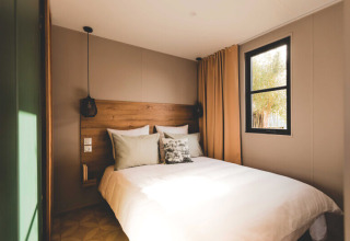 Camera da letto doppia accogliente presso O'Hara Lodge Comfort ad Arden Parks Tulderheyde, Belgio, con grande letto e finestra.