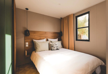 Camera da letto doppia accogliente presso O'Hara Lodge Comfort ad Arden Parks Tulderheyde, Belgio, con grande letto e finestra.