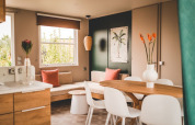 Moderne opholdsstue med træmøbler, spisebord, dekoreret med planter i O'Hara Lodge Comfort, Belgien.