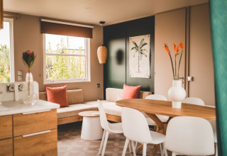 Zona giorno luminosa con arredi in legno all’O’Hara Lodge Comfort, Arden Parks Tulderheyde, Belgio.