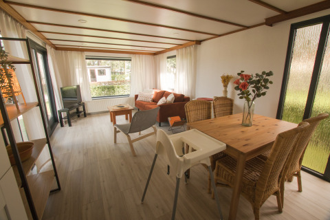 Gezellige woonruimte in Sun Lodge te Arden Parks Tulderheyde, België, met eettafel, sofa en veel licht.