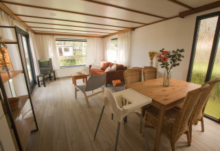 Gezellige woonruimte in Sun Lodge te Arden Parks Tulderheyde, België, met eettafel, sofa en veel licht.