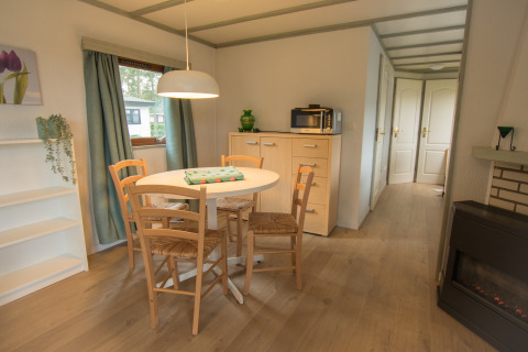 Eethoek met ronde tafel en vier stoelen in Sun Lodge op Arden Parks Tulderheyde, België.