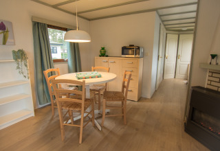 Eethoek met ronde tafel en vier stoelen in Sun Lodge op Arden Parks Tulderheyde, België.