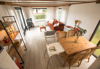 Lichte leefruimte in Sun Lodge, Arden Parks Tulderheyde, België, met eettafel, zetel en veel ramen.