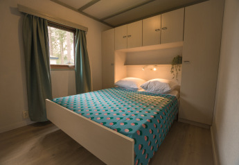 Slaapkamer met dubbel bed en kastruimte in de Sun Lodge van Arden Parks Tulderheyde, België.