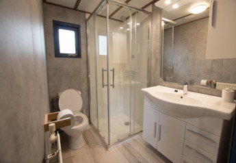 Moderne badkamer in Sun Lodge van Arden Parks Tulderheyde, België, met douche en stijlvol wit meubel.
