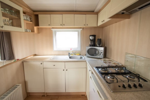 Cucina luminosa al Sun Lodge Comfort di Arden Parks Tulderheyde in Belgio, con fornelli e microonde.
