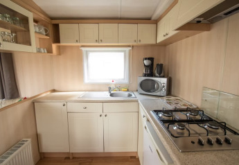 Cucina luminosa al Sun Lodge Comfort di Arden Parks Tulderheyde in Belgio, con fornelli e microonde.