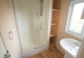 Bagno al Sun Lodge Comfort presso Arden Parks Tulderheyde, Belgio, con doccia, lavabo e mensole.