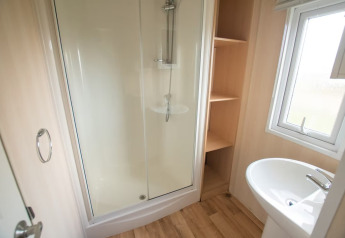 Bagno al Sun Lodge Comfort presso Arden Parks Tulderheyde, Belgio, con doccia, lavabo e mensole.
