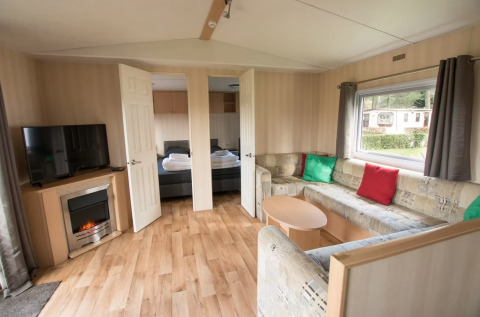 Soggiorno di Sun Lodge Comfort ad Arden Parks Tulderheyde, Belgio, con divano angolare e TV.