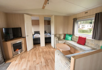 Soggiorno di Sun Lodge Comfort ad Arden Parks Tulderheyde, Belgio, con divano angolare e TV.