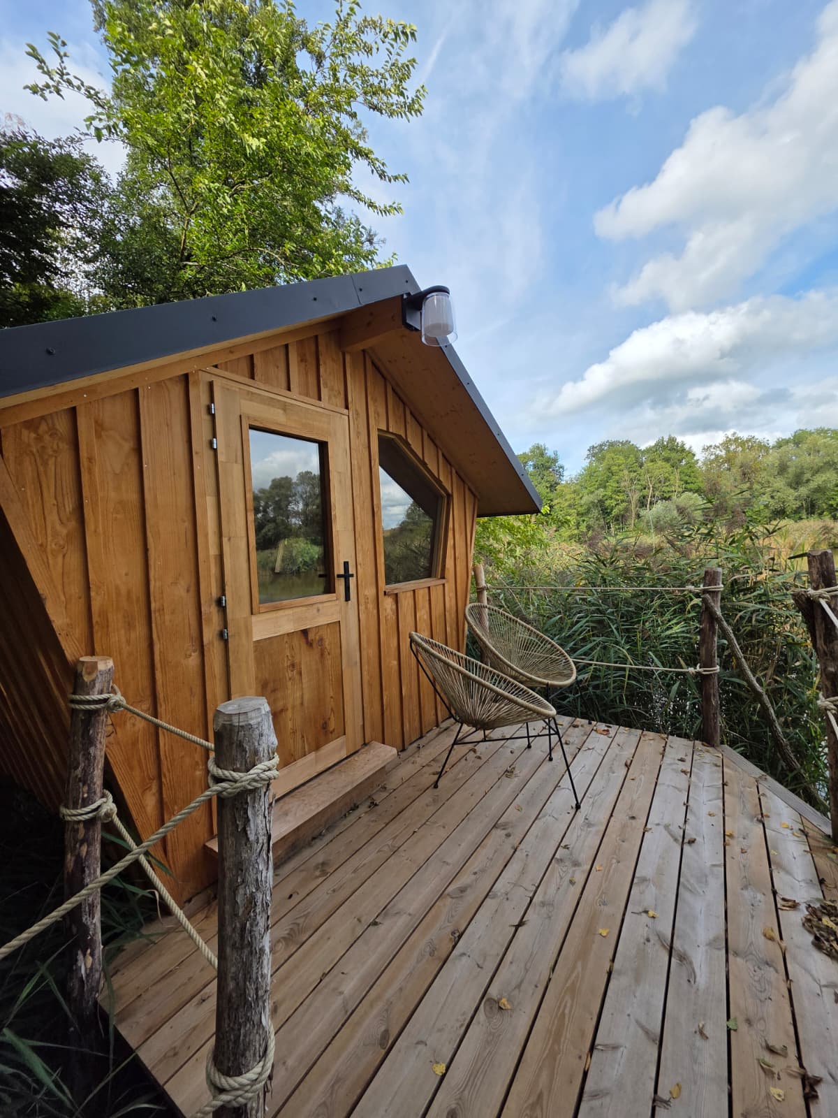 Moderne houten glamping hut op een terras, omringd door natuur, perfect voor een rustgevend uitje.