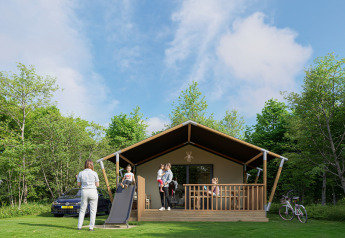 Familia disfruta de un día soleado en tienda safari en el bosque, niños juegan en tobogán y adultos descansan.