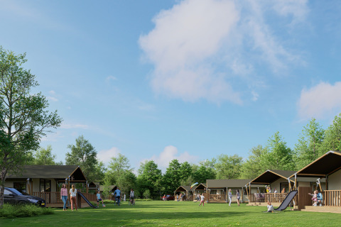 Safaritenten op een groene camping met families en spelende kinderen, omringd door bomen en blauwe lucht.
