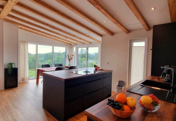 Moderne keuken en eetruimte in Chalet Enzian, Camping & Ferienpark Brilon, Duitsland, met mooi uitzicht.