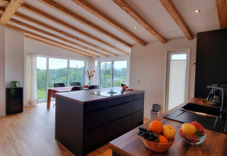 Moderne keuken en eetruimte in Chalet Enzian, Camping & Ferienpark Brilon, Duitsland, met mooi uitzicht.