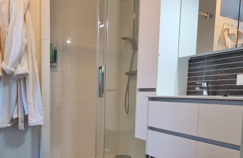 Salle de bain moderne au Chalet Limonet, Camping & Ferienpark Brilon, avec douche, lavabo et miroir.