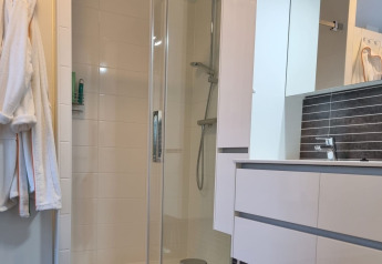 Modern bathroom in Chalet Limonet, Camping & Ferienpark Brilon, featuring shower, sink, and mirror.