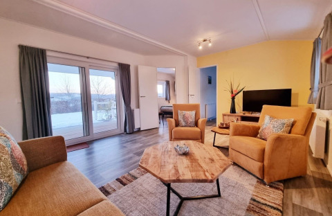 Salon lumineux et confortable du Chalet Limonet au Camping & Ferienpark Brilon, Allemagne, avec mobilier moderne.