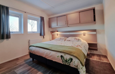 Chambre du Chalet Limonet au Camping & Ferienpark Brilon, Allemagne, avec lit double et rangements.
