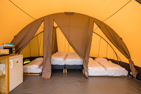 Interior view of a De Waard Safari Tunnel Tent with beds and amenities at Kampeerdorp de Zandstuve, Netherlands