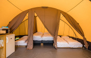 Interior view of a De Waard Safari Tunnel Tent with beds and amenities at Kampeerdorp de Zandstuve, Netherlands