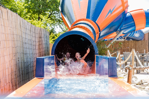 Twee kinderen genieten van een kleurrijke waterglijbaan bij Kampeerdorp de Zandstuve in Nederland.