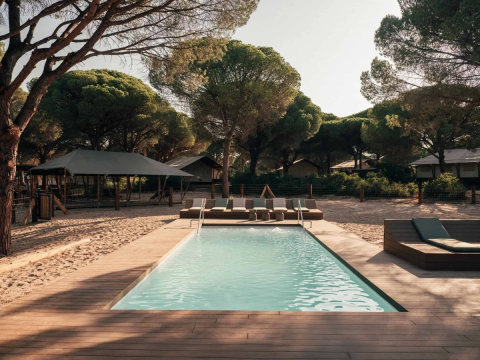 Zwembad met ligstoelen en tenten bij Wecamp Cádiz-vakantiepark in Andalusië, Spanje.