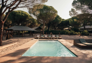Zwembad met ligstoelen en tenthuisjes bij Wecamp Cádiz vakantiepark in Andalusië, Spanje.