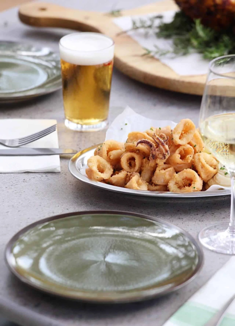 Une assiette de calamars frits, bière et vin sur une table à Wecamp Cádiz en Andalousie, Espagne.