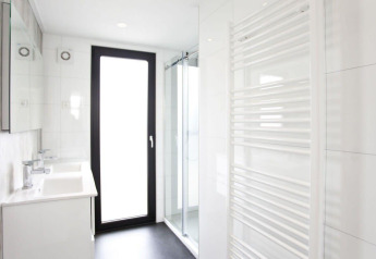 Modern badkamer in het L-Cube lodge aan de Zuiderzee in Nederland met glazen douche en grote deur.